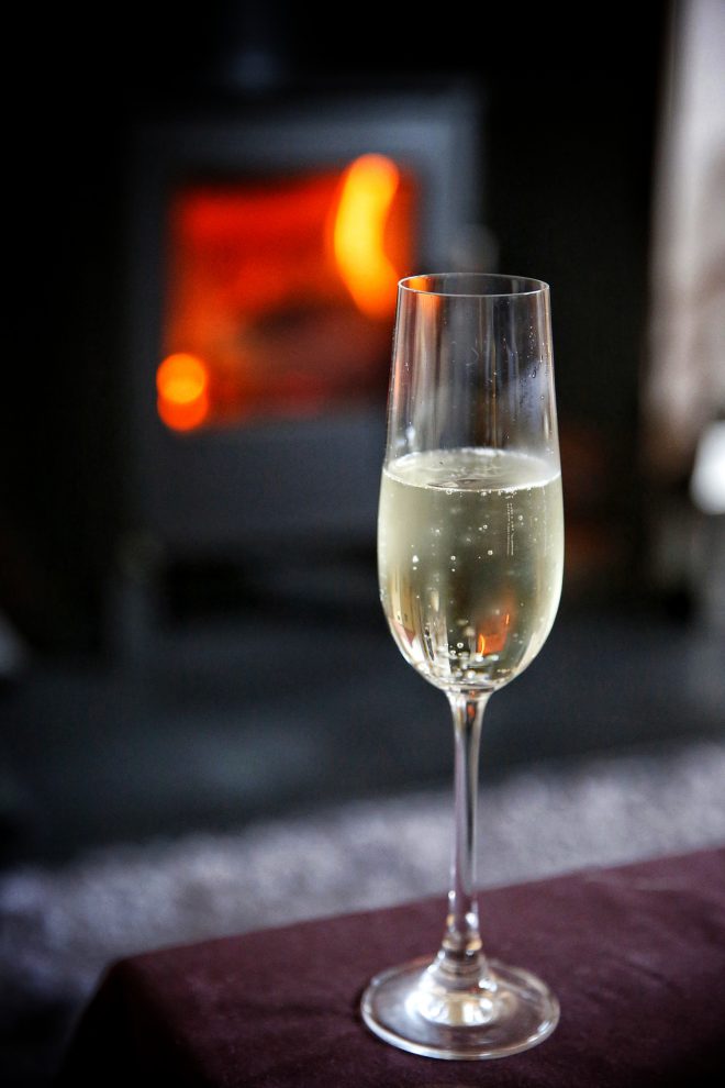 Glass of Prosecco in front of the fire